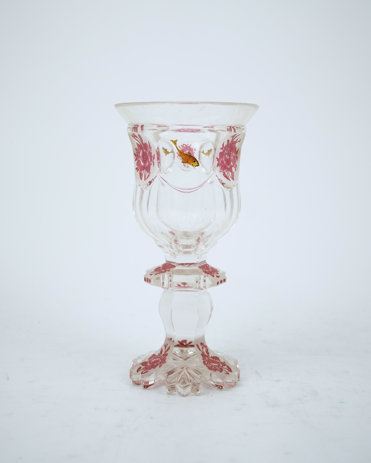 Two Bohemian transparent enamelled ‘fish’ beakers, and a similar faceted goblet, c.1840-60